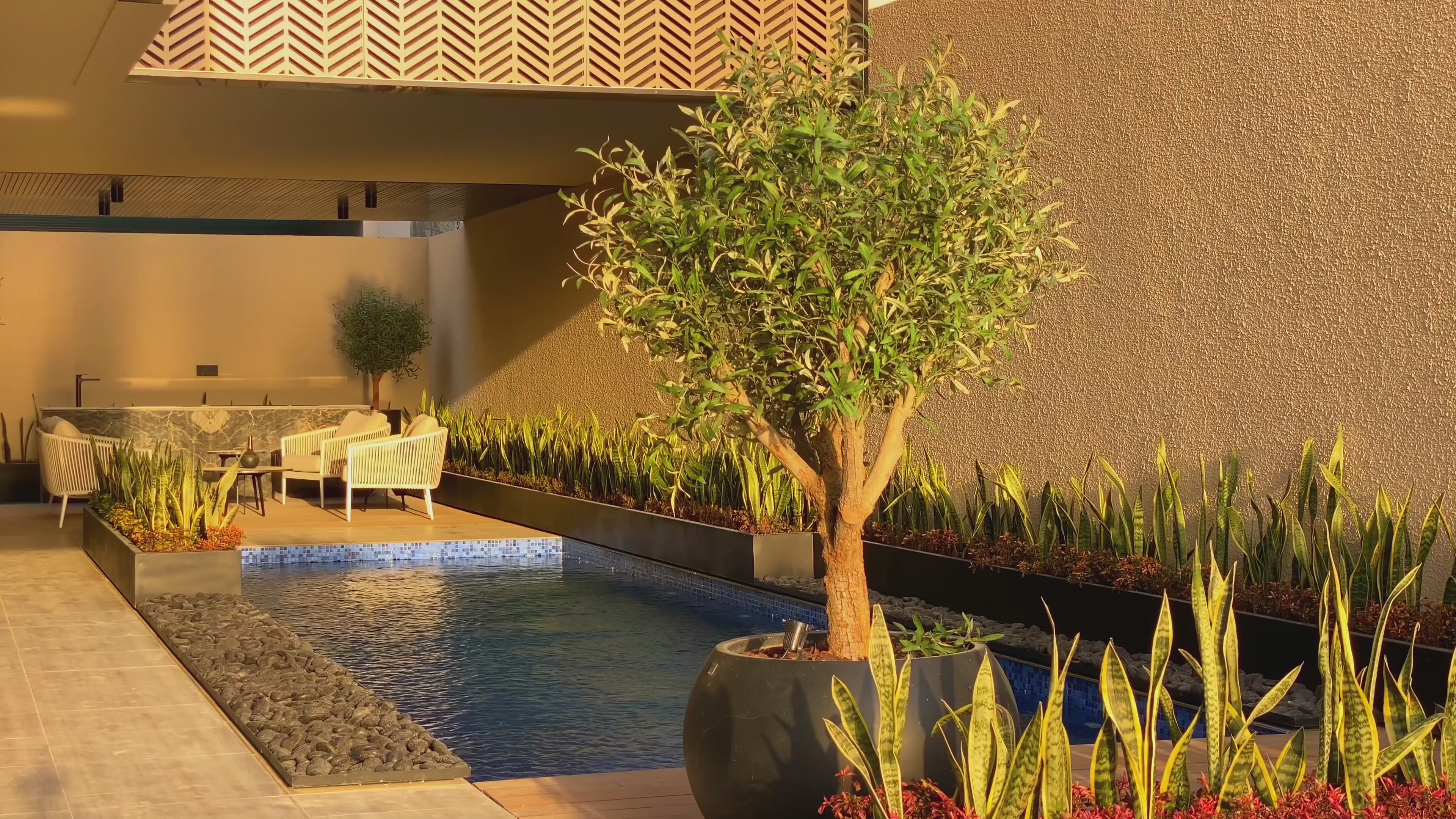 Luxury backyard pool with modern fire features and illuminated water fountains at dusk
